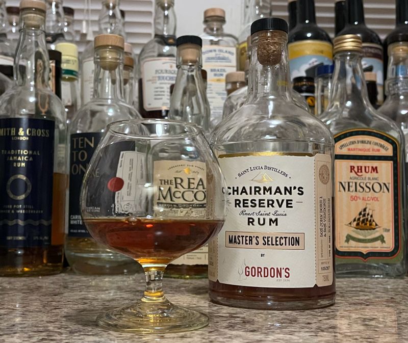 A bottle of Chairman's Reserve Master's Selection next to a glencairn of rum on a kitchen counter