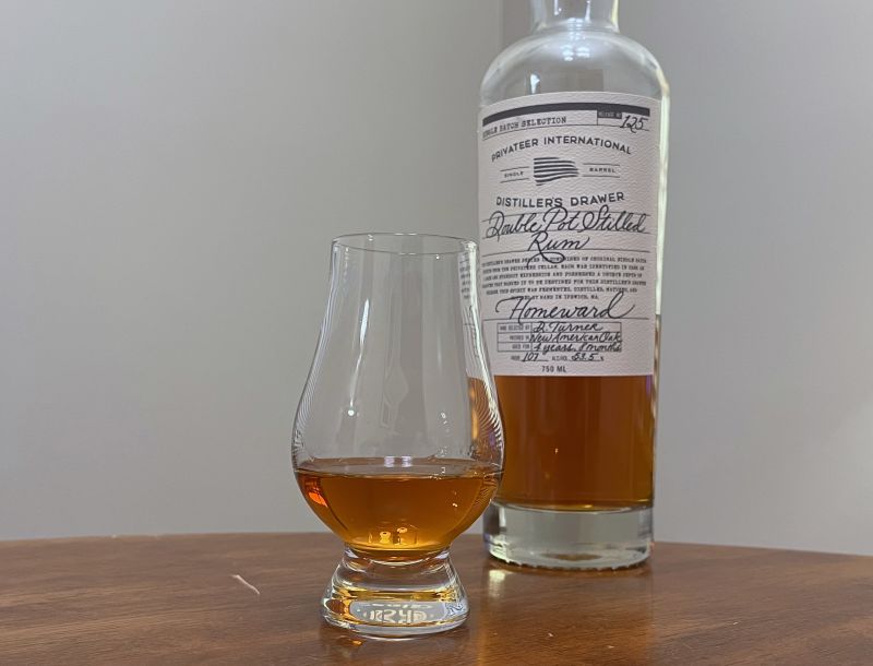 A bottle of Privateer DD Homeward next to a glencairn of rum on a kitchen counter