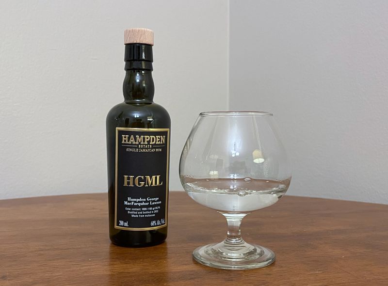 A bottle of Hampden 8 Marks HGML next to a glass of rum
