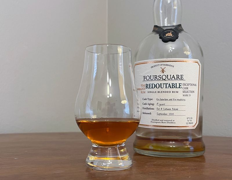 A bottle of Foursquare Redoutable next to a glass of rum