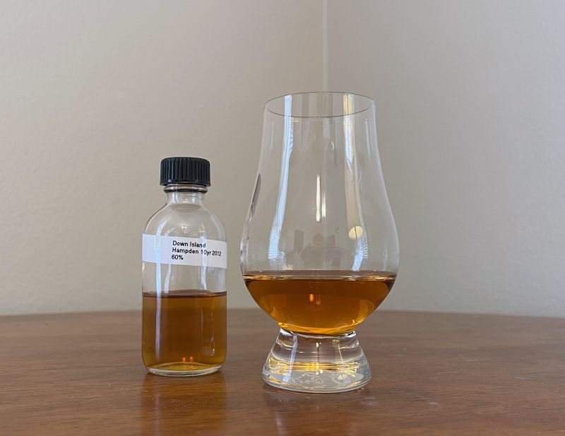 A bottle of Down Island Spirits Jamaica HD 2012 10 year next to a glass of rum