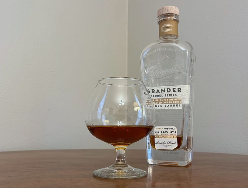 A bottle of Grander Toasted Oak Single Barrel next to a glass of rum