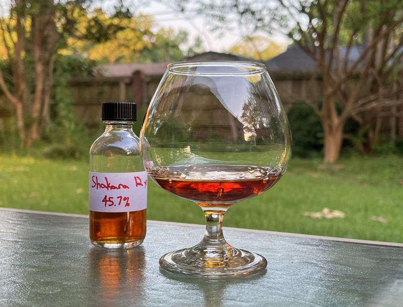 A bottle of Shakara 12 year next to a glass of rum