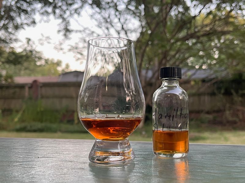 A bottle of Hamilton Saint Lucia 10 year next to a glass of rum