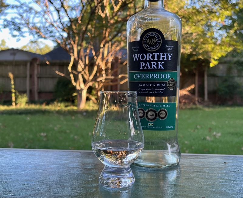 A bottle of Worthy Park Overproof next to a glass of rum
