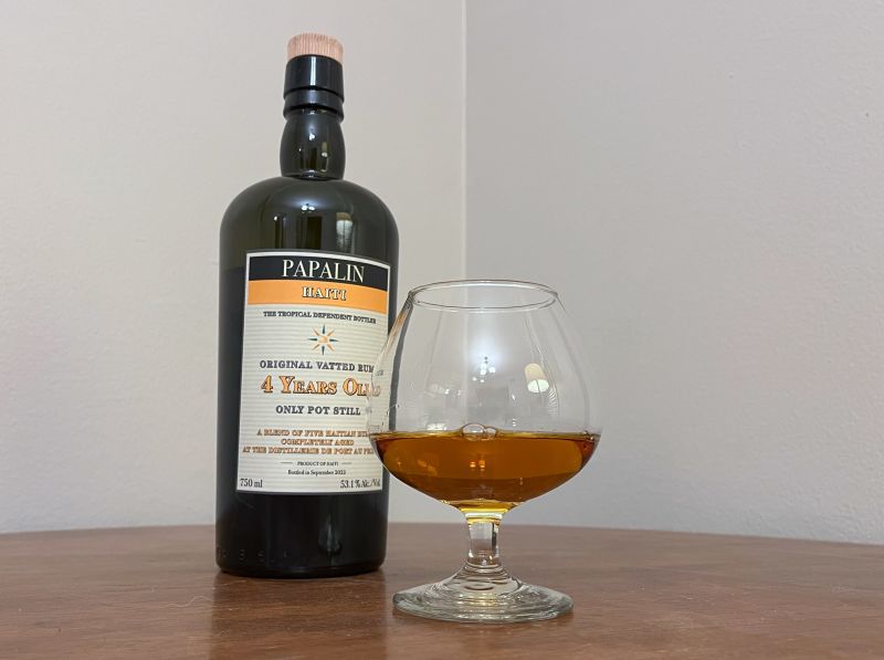 A bottle of Papalin Haiti 4 year next to a glass of rum