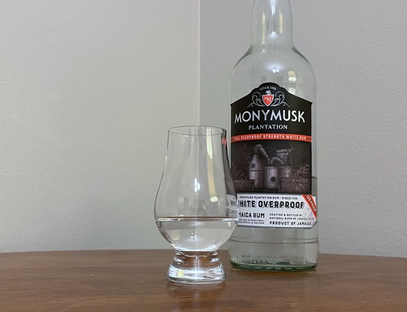 A bottle of Monymusk Overproof next to a glass of rum