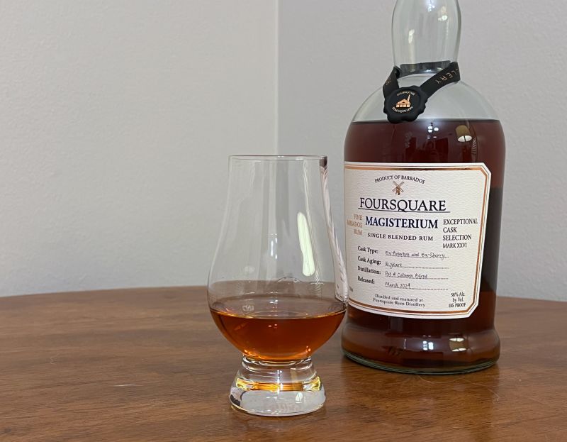A bottle of Foursquare Magisterium next to a glass of rum