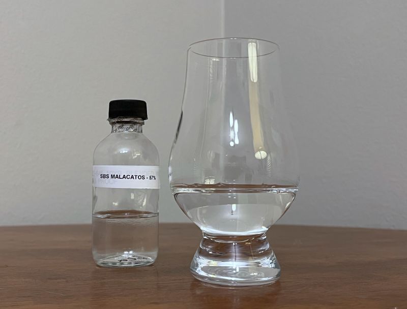 A bottle of S.B.S. Origins Ecuador Malacatos next to a glass of rum