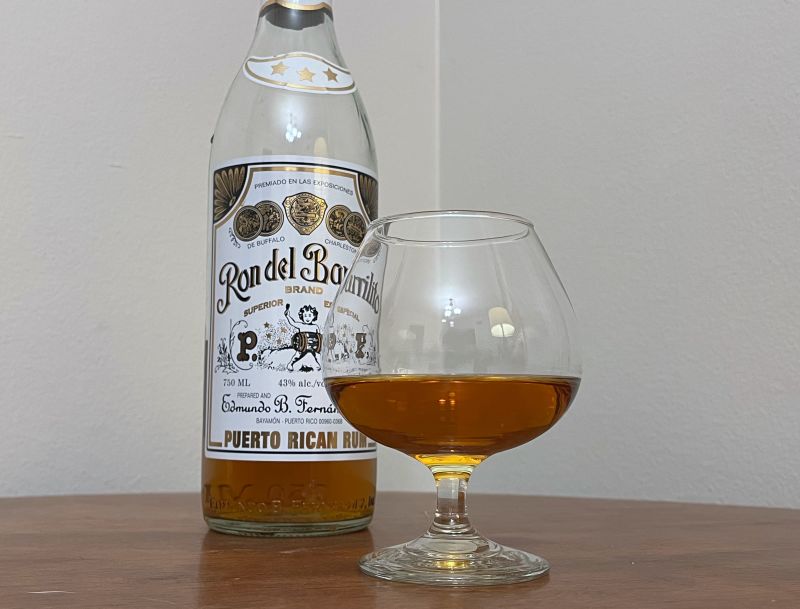 A bottle of Ron del Barrilito 3 Stars next to a glass of rum