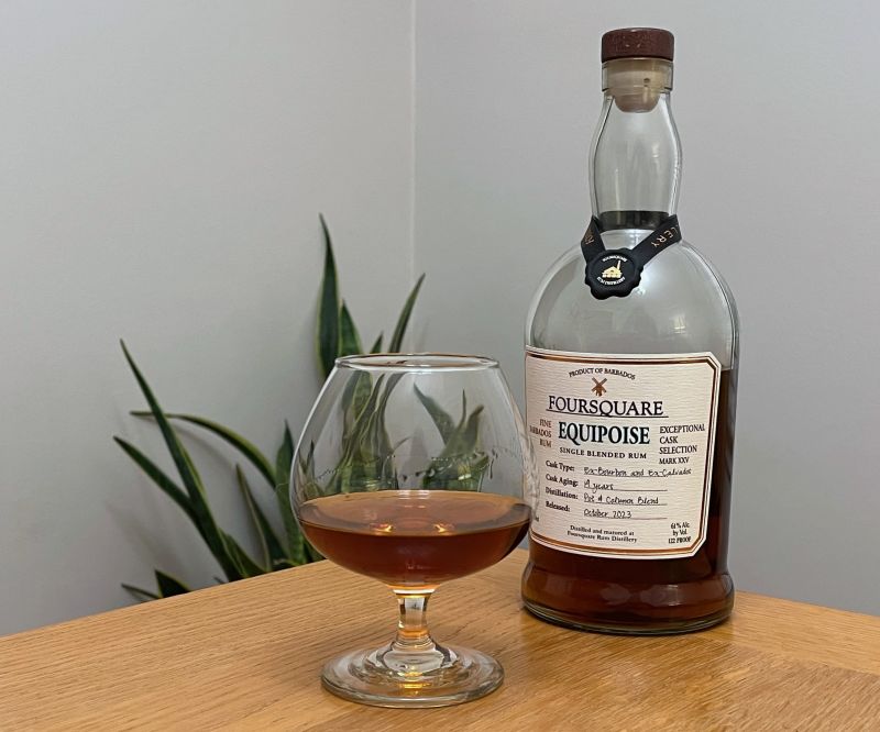A bottle of Foursquare Equipoise next to a glass of rum