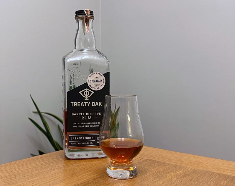 A bottle of Treaty Oak Barrel Reserve Rum - Barrel No. 443 next to a glass of rum