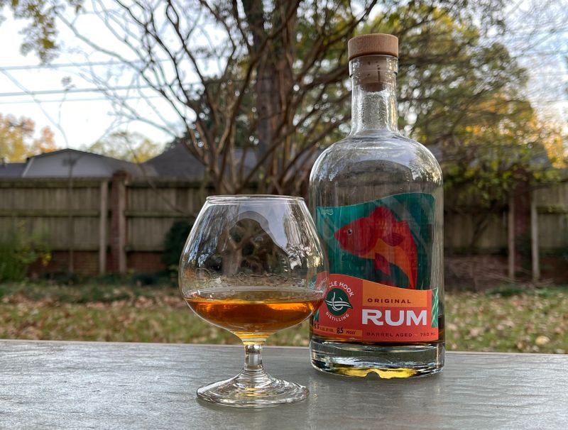 A bottle of Circle Hook Distilling Barrel Aged Rum next to a glass of rum