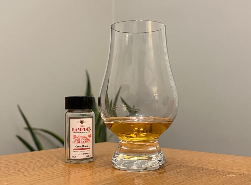 A bottle of Hampden Great House 2024 next to a glass of rum