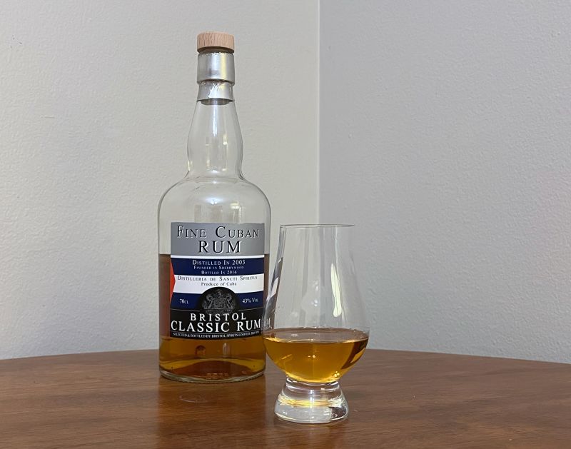 A bottle of Bristol Fine Cuban Rum next to a glass of rum