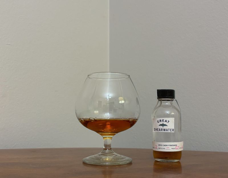 A bottle of Great Shearwater Trinidad 14 year Rye Cask Finish next to a glass of rum