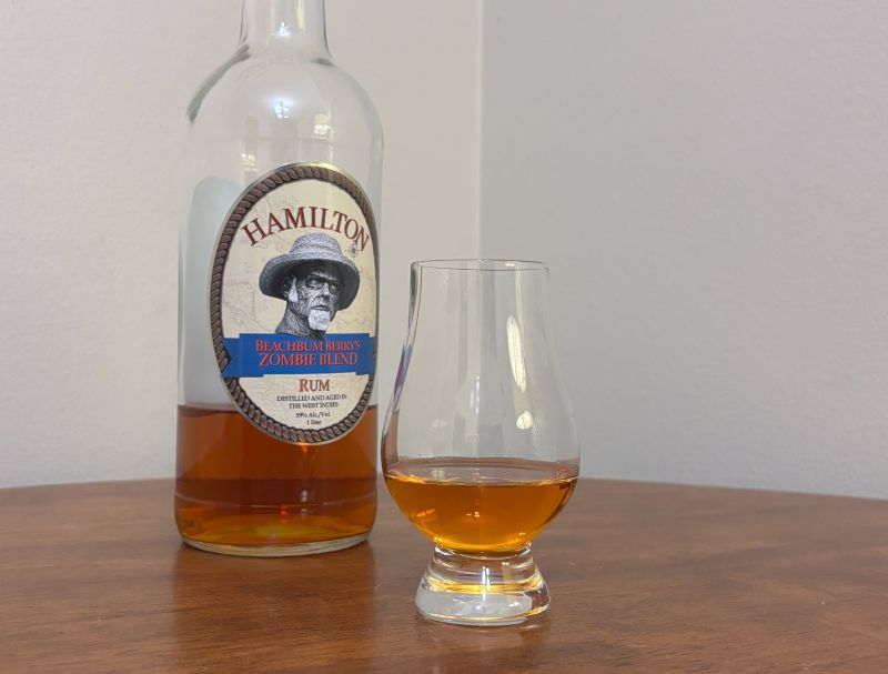 A bottle of Hamilton Beachbum Berry's Zombie Blend next to a glass of rum