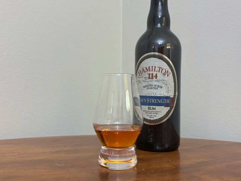 A bottle of Hamilton 114 Navy Strength next to a glass of rum