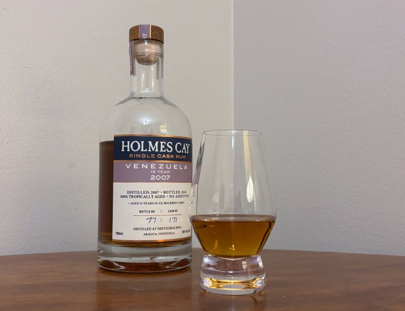 A bottle of Holmes Cay Venezuela 2007 next to a glass of rum