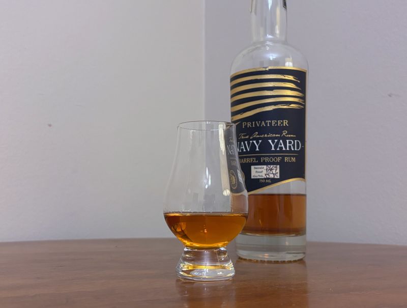 A bottle of Privateer Navy Yard P604 next to a glass of rum
