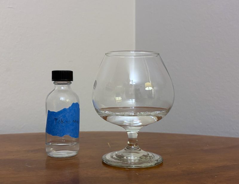 A bottle of Tokyo Nights next to a glass of rum