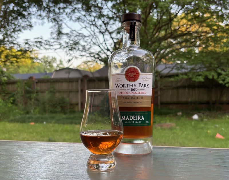 A bottle of Worthy Park Special Cask Series Madeira 10 year next to a glass of rum