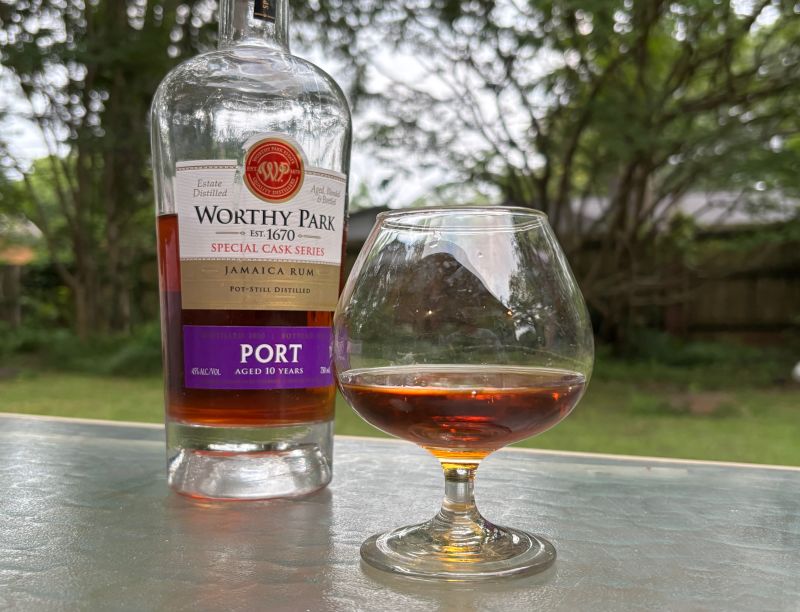 A bottle of Worthy Park Special Cask Series Port 10 year next to a glass of rum