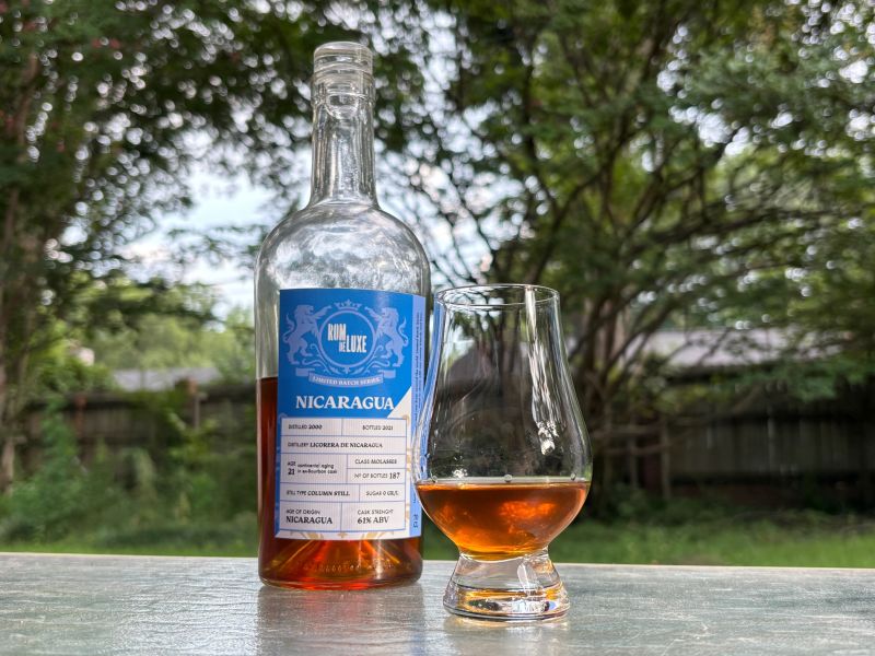 A bottle of Rom de Luxe Nicaragua 21 year next to a glass of rum