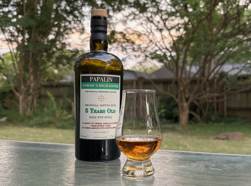 A bottle of Papalin Jamaica High Ester 5 year next to a glass of rum