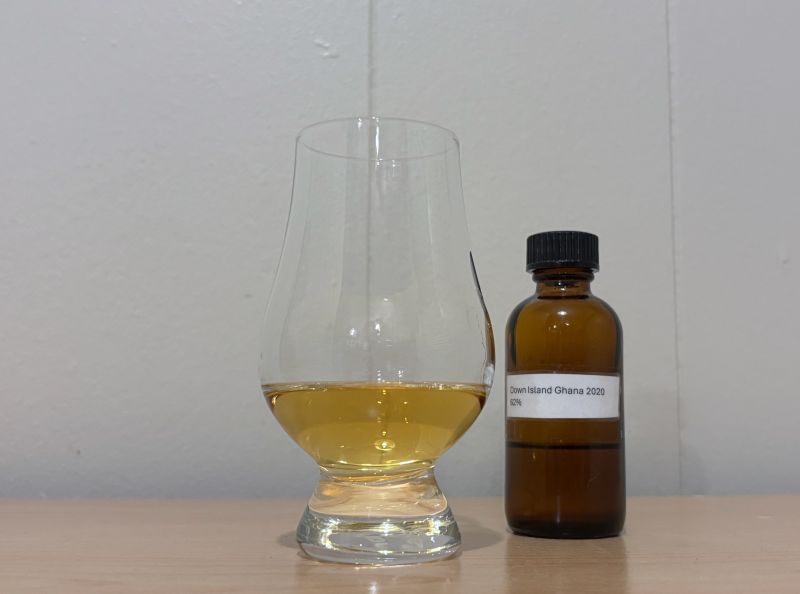 A bottle of Down Island Spirits Ghana 2020 3 year next to a glass of rum