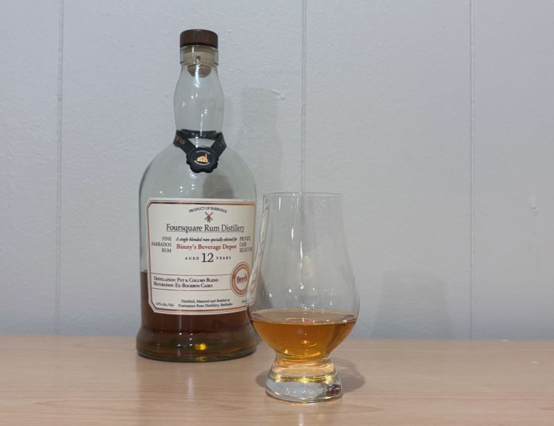 A bottle of Foursquare Binny's Private Cask 12 year next to a glass of rum