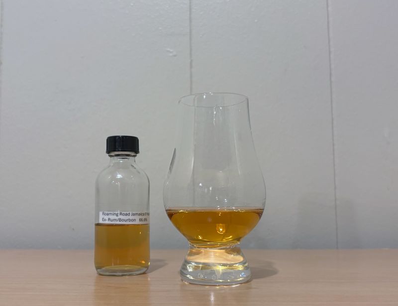 A bottle of Roaming Road Jamaica 9 year next to a glass of rum