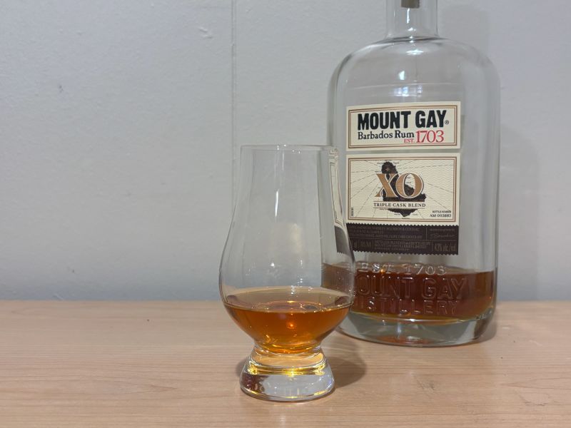 A bottle of Mount Gay XO next to a glass of rum