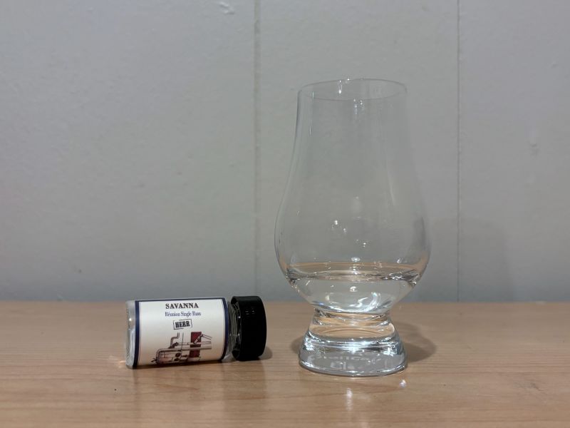 A bottle of Habitation Velier Savanna HERR Réunion Single Rum next to a glass of rum