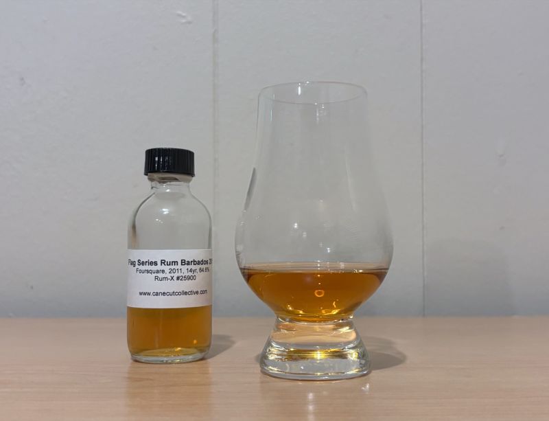 A bottle of Flag Series Barbados next to a glass of rum