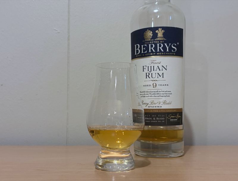 A bottle of Berrys' Finest Fijian Rum 9 year next to a glass of rum