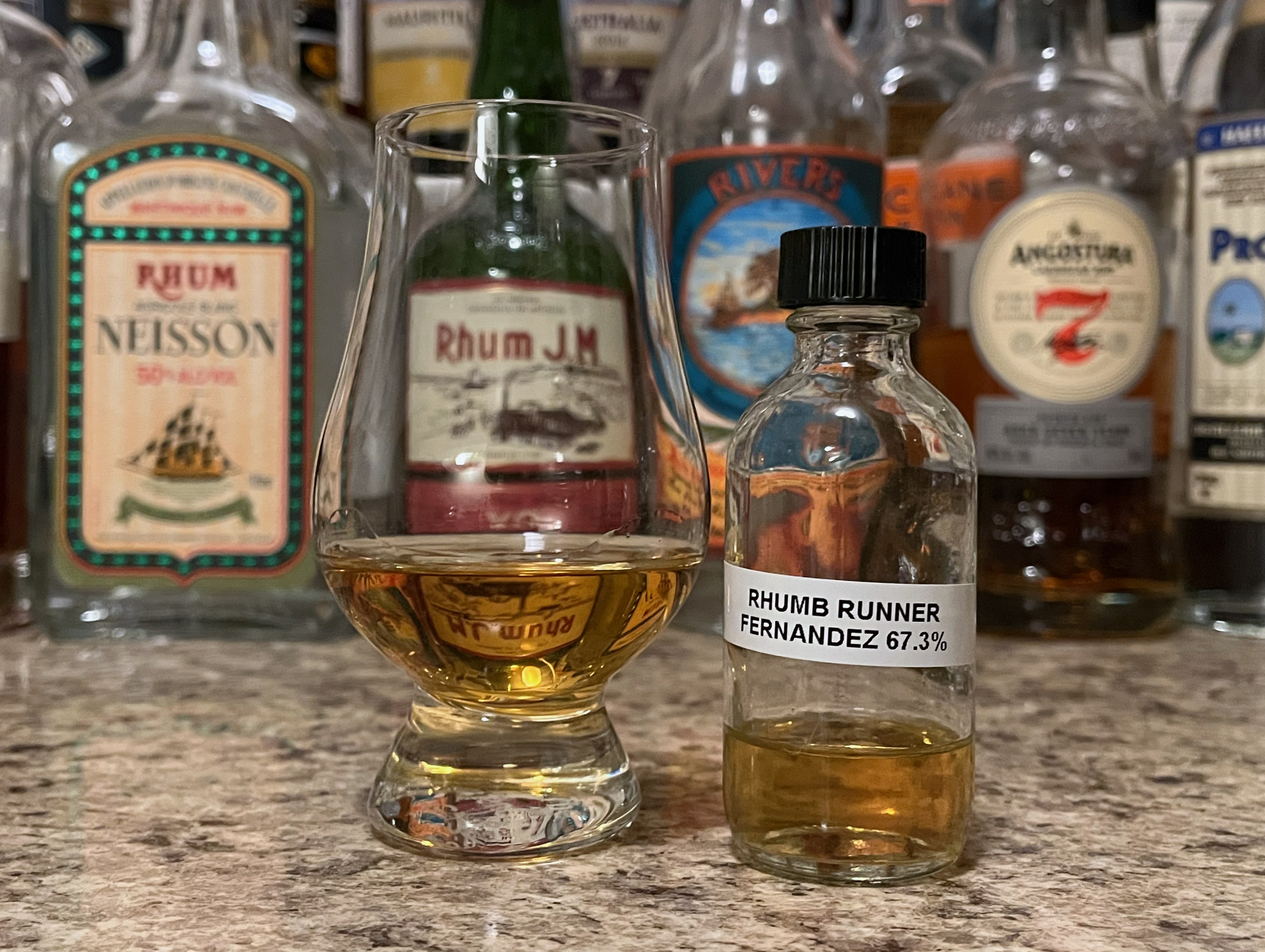 Bottle of Rhumb Runner Fernandes sitting next to a rum-filled glencairn