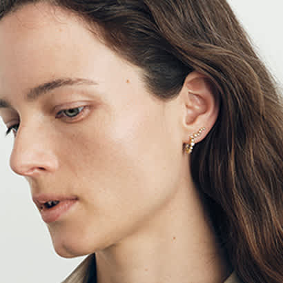 earhoop and earring in 18 karat yellow gold with diamonds on model from the georg jensen signature diamonds collection