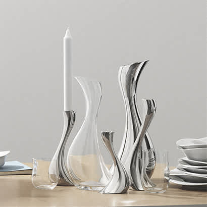 candleholders and pitcher in stainless steel and glass carafe from the cobra collection by georg jensen