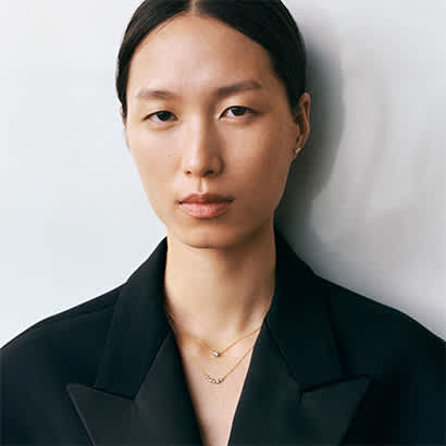 necklaces and earring in diamond and 18 yellow gold karat from the georg jensen signature diamond collection on model