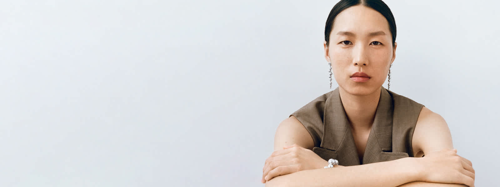 Woman wearing earrings and bracelet in sterling silver from Moonlight Grapes collection