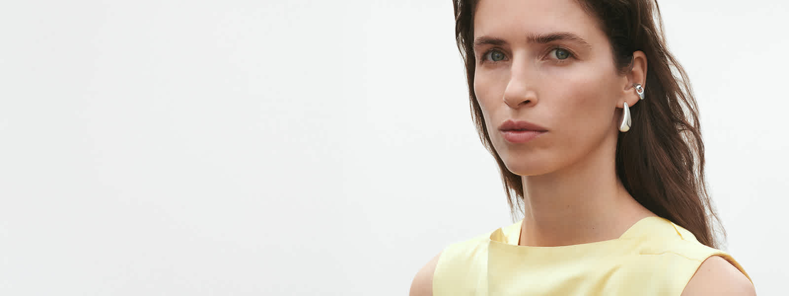 Model wearing earrings and earcuff in sterling silver from Reflect collection