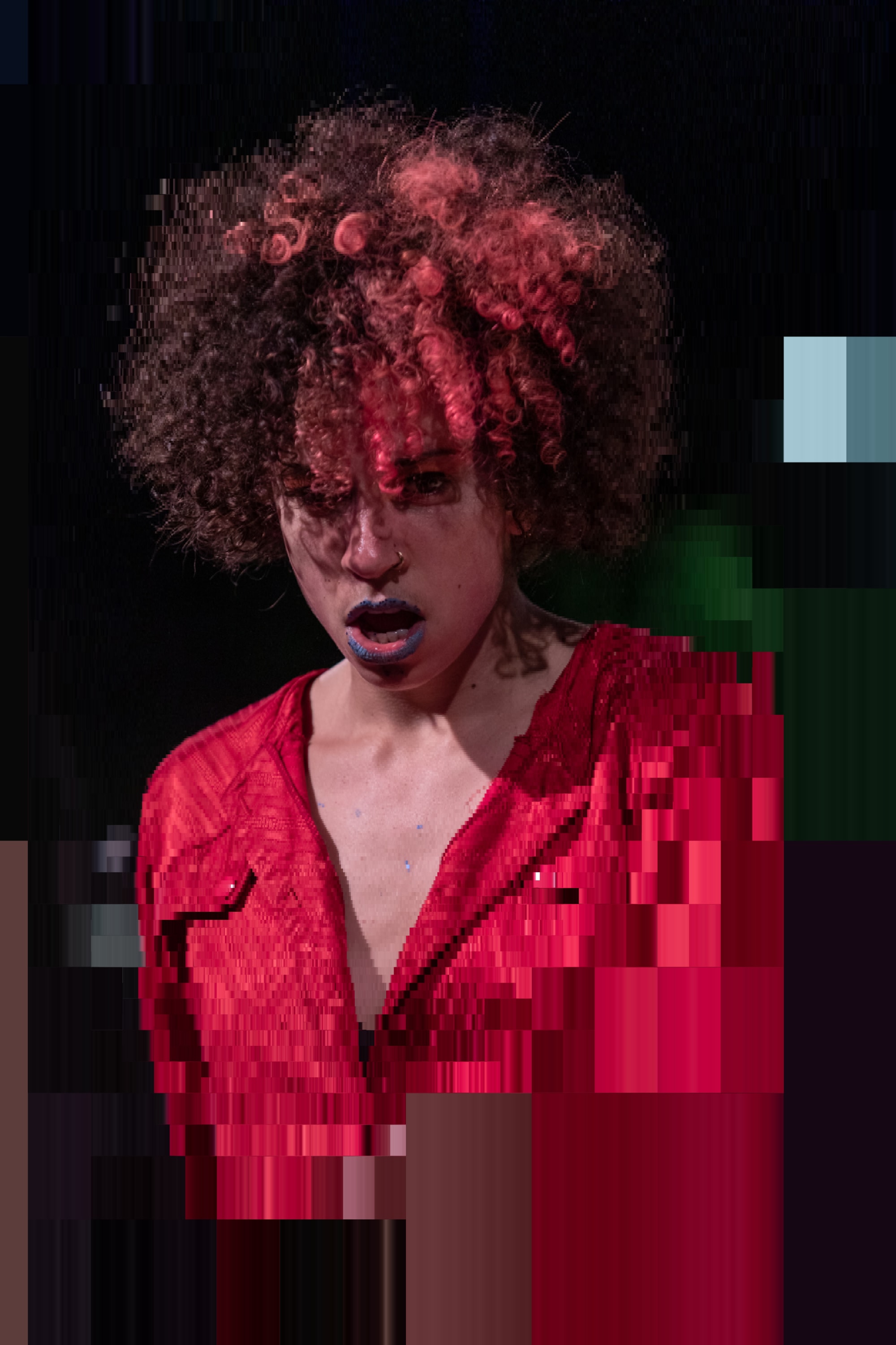 Mélissa wears glittery lipstick and a red dyed afro.