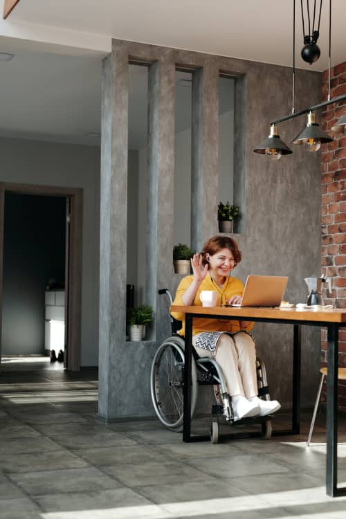 woman in wheelchair working at desk on web call