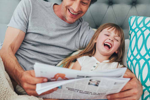 Father daughter reading newspaper