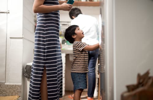 Child standing in front of mother looking up