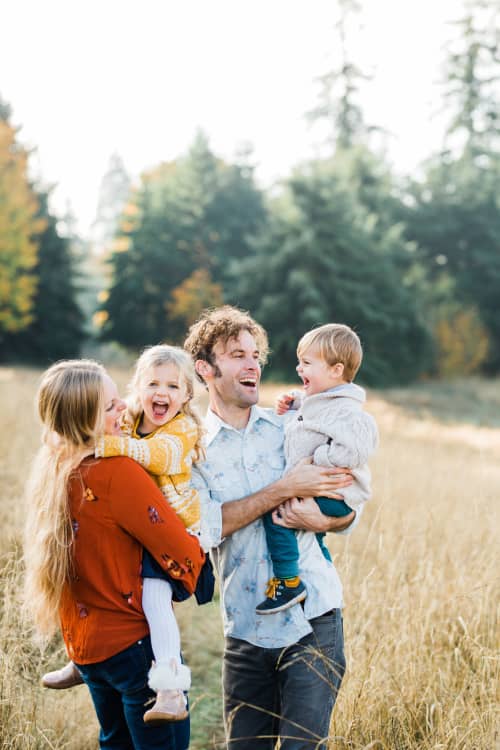 young family walking through field