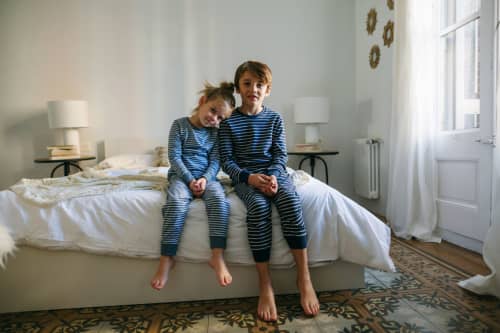 Brother and sister in pajamas waking up