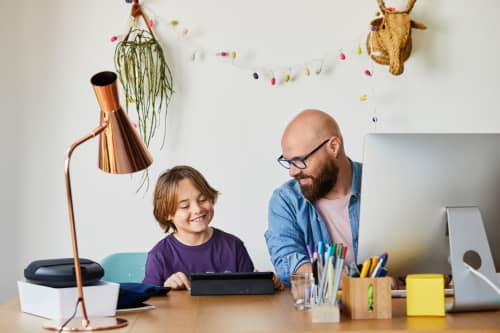 Dad sitting with son at desk