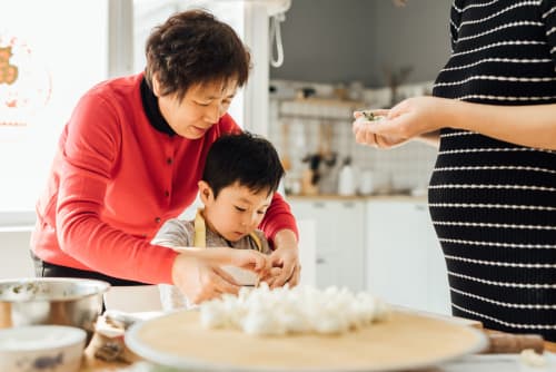 Grandmother helps child cook